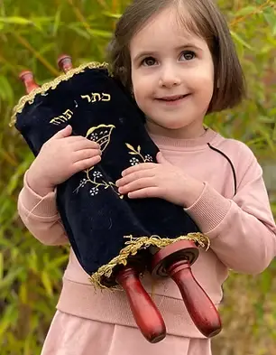 Girl holding Torah in our preschool program