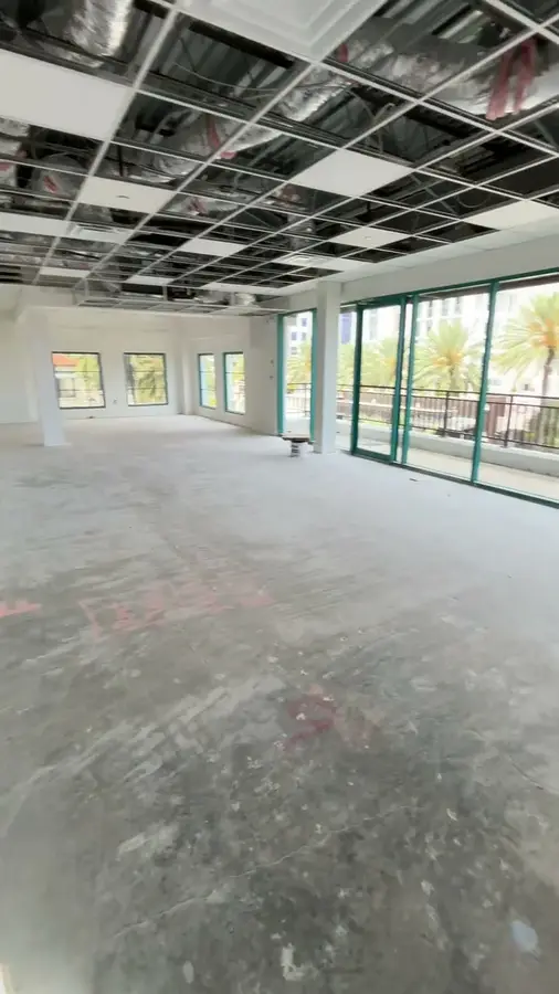 The DoBo Loft's raw, unfinished interior, looking out toward the balcony and Downtown Boca