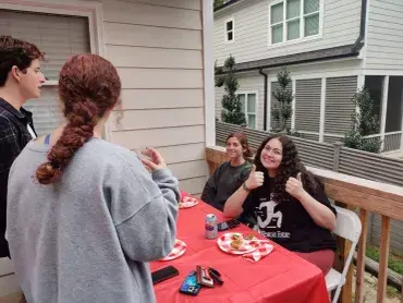 Friends enjoying a meal together on a porch.